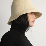Bucket z rafii w kolorze naturalnym na modelce w czarnym golfie